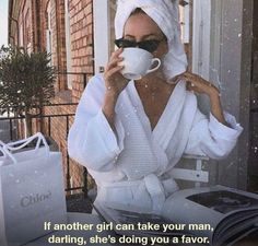 a woman with a towel wrapped around her head drinking from a coffee cup and reading a book