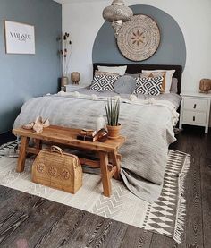 a bed room with a neatly made bed next to a wooden table and luggage on the floor