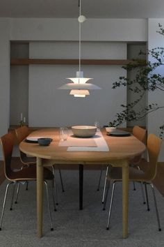 a dining room table with chairs and plates on it