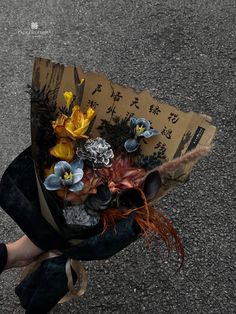 a woman holding a bouquet of flowers on the street