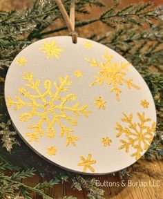 a white ornament with gold snowflakes on it