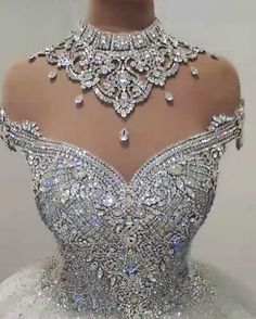 the back of a wedding dress that is covered in crystal stones and beads, with an elaborate neckline