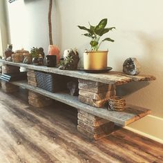 a wooden shelf with potted plants on it