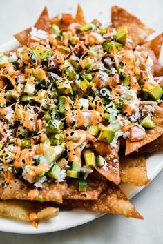 a white plate topped with nachos covered in cheese