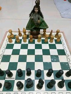 a chess board with a doll sitting on top of it