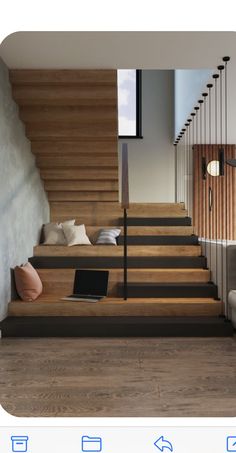 a laptop computer sitting on top of a wooden stair case next to a white couch