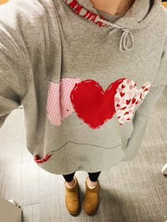 a woman wearing a sweatshirt with a heart on it