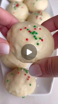 a person is holding up some cookies with sprinkles on them and pointing at it