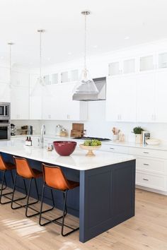 a kitchen with white cabinets and blue island