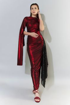 Metallic red bodyfit gown with cape sleeve on one side and a black sequined trail on the other side. - Aza Fashions Fitted Gown With Cape Sleeves For Parties, Festive Fitted Evening Dress For Red Carpet, Fitted Party Dress With Draped Sleeves, Fitted Dress With Cape Sleeves For Party, Red Carpet Festive Fitted Evening Dress, Festive Red Carpet Fitted Evening Dress, Draped Sleeve Party Dresses, Traditional Drape Sequin Fabric With Resham Embroidery, Festive Red Gown With Cutdana