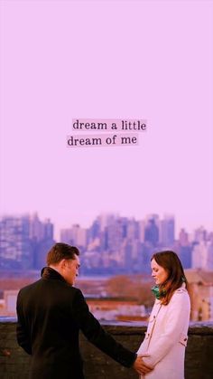 a man and woman standing next to each other on top of a roof with the words dream a little dream of me