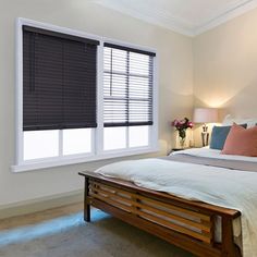 a bed with white sheets and pillows in a bedroom