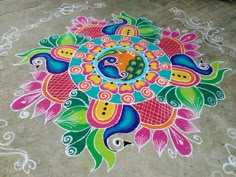 a colorful flower design is painted on the ground