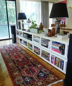 an image of a living room with furniture and rugs on the floor in front of a window