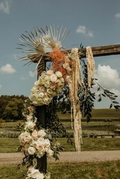 a cross decorated with flowers and greenery