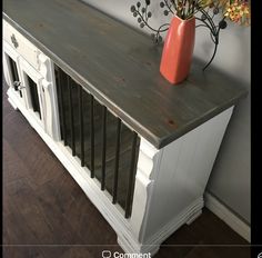 a vase filled with flowers sitting on top of a wooden table next to a wall