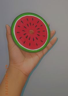 a hand holding a piece of paper with a watermelon design on it