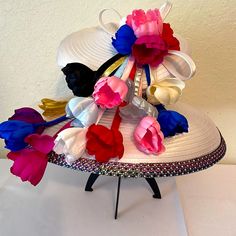 This Charm’s Church Hat Is Embellished With Pink, Blue, White, Purple, Red, Black, Gold, Silver, Flowers Placed On The Middle Right Side Of This Gorgeous Hat. This Hat Is Adorned With Four Rows Of Acrylic Rhinestones At The Rim And Middle Of It. Beautiful Exotic Brightly Colored That You Can Wear With Any Outfit. . Elegant Multicolor Hat For Evening, Elegant Multicolor Evening Hat, Multicolor Evening Hats For Summer, Elegant Multicolor Brimmed Hat, Multicolor Summer Evening Hats, Multicolor Mini Hats For Royal Ascot, Elegant Multicolor Mini Hats For Kentucky Derby, Elegant Multicolor Mini Hat For Royal Ascot, Mini Hats For Kentucky Derby Celebration