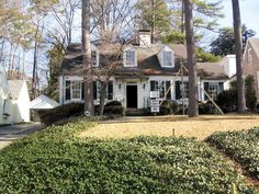 a white house surrounded by trees and bushes