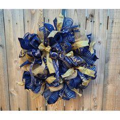 a blue and gold wreath hanging on a wooden fence