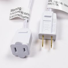 two white electrical plugs are connected to each other