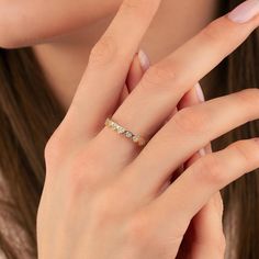 a woman's hand with a diamond ring on her left hand and the middle finger