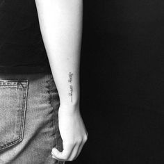 a woman with a tattoo on her arm holding onto the back of her left arm