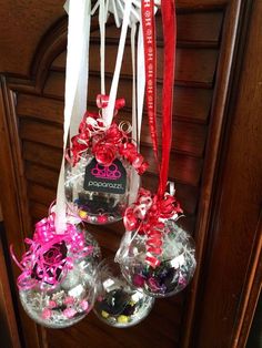 three ornaments hanging from a door hanger with ribbons and bows on the front of them