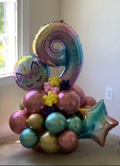 a birthday cake made out of balloons with the number nine on it's top