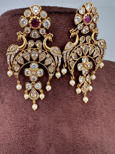 Peacock CZ Matte Chandballi pushback earringsColor : Matte GoldenSize : Length : 2.75 Inches; Weight : 13 grams eachStones : AD Stones Pearls Beads Diwali Chandbali Jeweled Earrings, Bollywood Party Earrings With Peacock Design, Bridal Chandbali Earrings With Peacock Design For Festivals, Bridal Peacock Chandbali Earrings For Festivals, Bollywood Chandbali Jeweled Earrings, Festival Bridal Chandbali Earrings With Peacock Design, Bollywood Style Peacock Design Earrings For Party, Bollywood Style Peacock Earrings For Party, Bollywood Style Peacock Earrings For Festive Occasions