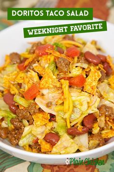 a white bowl filled with taco salad on top of a green and yellow table cloth