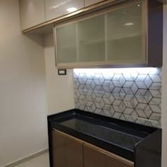 an empty kitchen with white cabinets and black counter tops