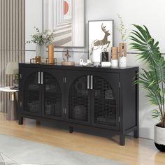 a living room with a large black cabinet and potted plant on the sideboard