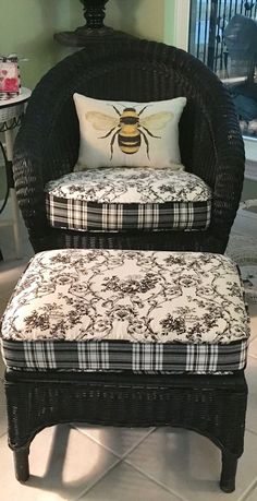 a wicker chair and ottoman with a bee pillow