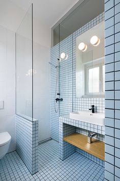 a bathroom with blue and white tiles on the walls, floor, and shower stall