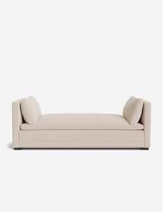 a white couch sitting on top of a wooden floor next to a gray wall in front of it