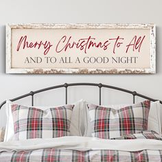 a bed with plaid pillows and a merry christmas sign above it that reads,'merry christmas to all and to all a good night '