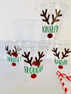 three plastic cups with reindeer noses on them and candy canes in front of them