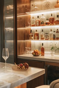 a bar with bottles and glasses on the counter, next to a wine glass filled with oranges