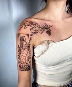 a woman with a cross and flowers tattoo on her left shoulder, wearing a white top