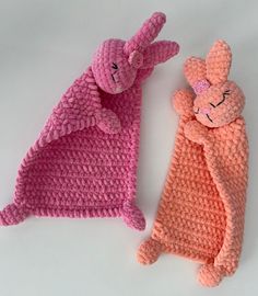 two crocheted stuffed animals laying next to each other