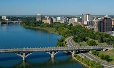 an aerial view of a bridge over a body of water with buildings in the background