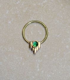 a gold ring with a green stone in the middle