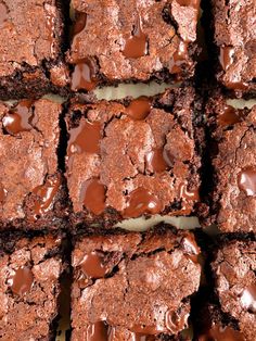 brownies with chocolate frosting are stacked on top of each other and have been cut into squares