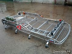 a large metal bed sitting on top of a wet ground