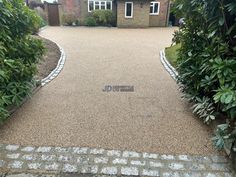 a driveway with gravel and brick edging