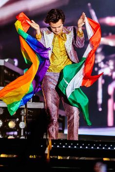 a man in a yellow shirt and tie is dancing on stage