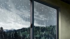 an open window with rain falling down on the outside and trees in the distance behind it