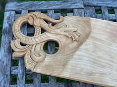 an intricate carved wooden object sitting on top of a bench