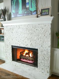 a fireplace with a fire burning in it's mantle next to a painting on the wall